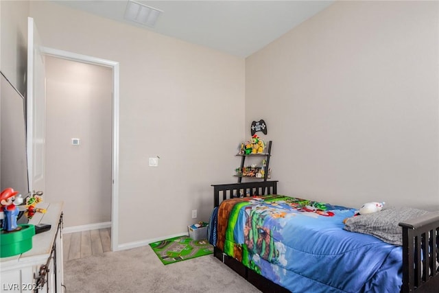 bedroom with light carpet, visible vents, and baseboards