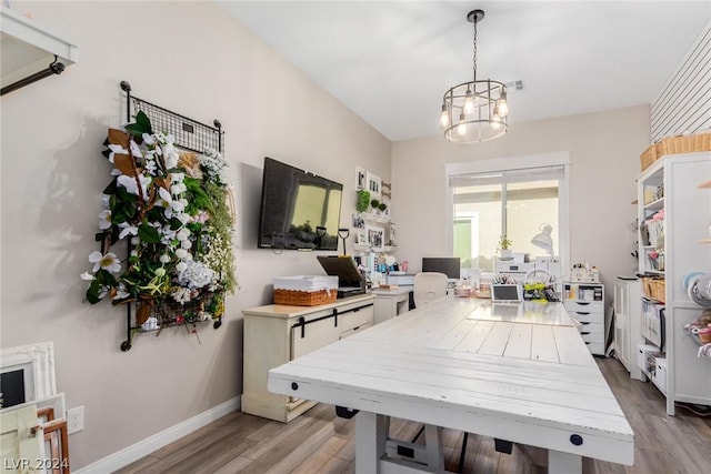 home office with light wood finished floors, visible vents, baseboards, and an inviting chandelier