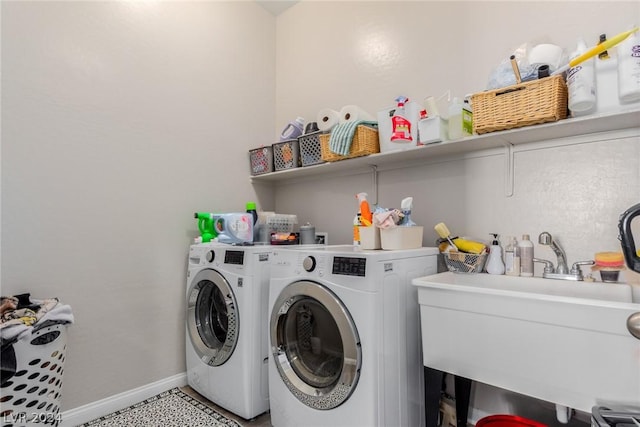 laundry room with laundry area, separate washer and dryer, a sink, and baseboards