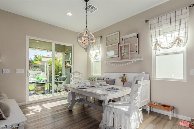 dining room featuring baseboards, visible vents, wood finished floors, an inviting chandelier, and recessed lighting