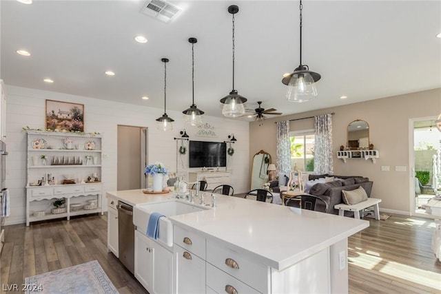 kitchen featuring a sink, white cabinets, light countertops, dishwasher, and a center island with sink