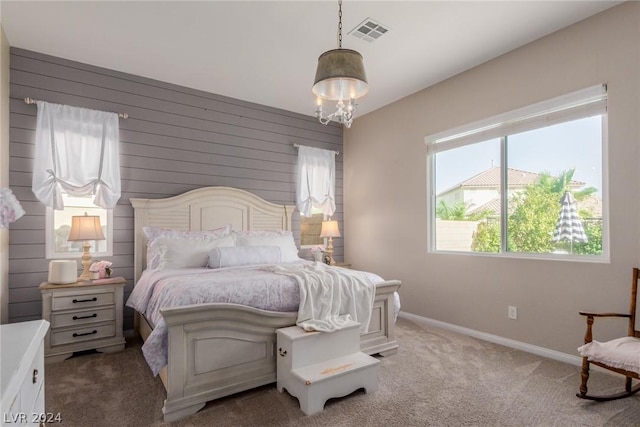 carpeted bedroom with visible vents, baseboards, and an inviting chandelier