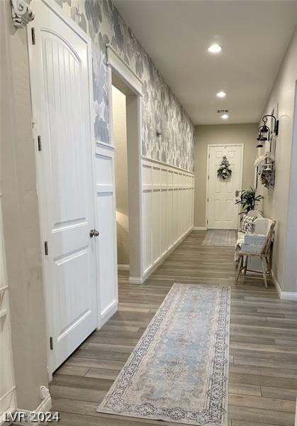 hall with recessed lighting, wood finished floors, a wainscoted wall, and wallpapered walls