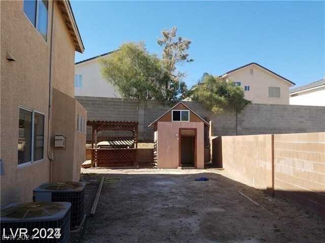 view of patio / terrace featuring a pergola, central air condition unit, and a storage shed