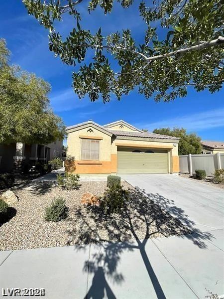 view of front facade featuring stucco siding, driveway, a tile roof, fence, and an attached garage