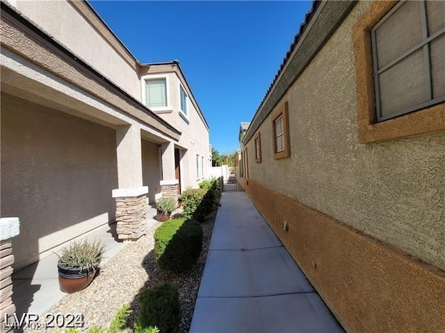 view of home's exterior with fence, stone siding, and stucco siding