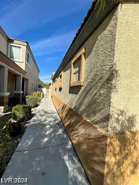 view of side of property featuring stucco siding and fence