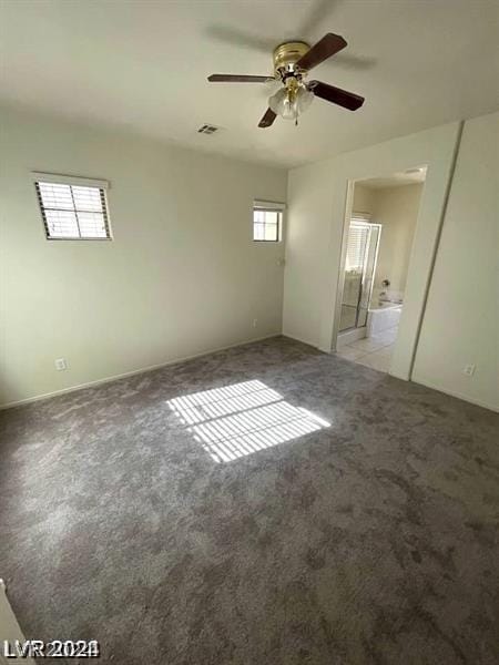 unfurnished bedroom with visible vents, connected bathroom, a ceiling fan, and carpet floors