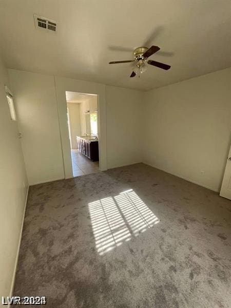 interior space with visible vents, a ceiling fan, and carpet flooring