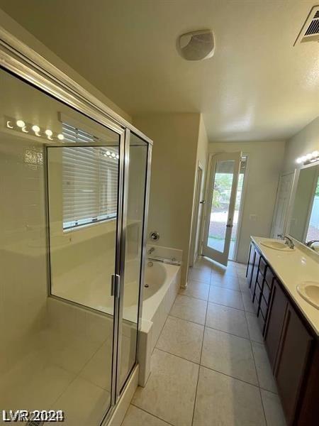 bathroom featuring visible vents, double vanity, tile patterned flooring, a shower stall, and a bath