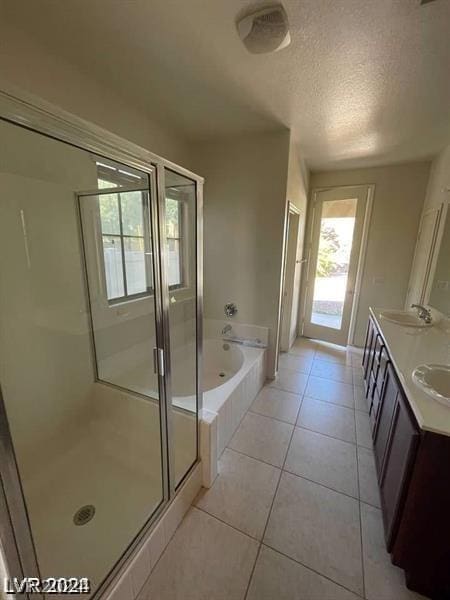 full bath with a garden tub, double vanity, a stall shower, tile patterned floors, and a textured ceiling