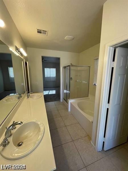 bathroom with tile patterned flooring, visible vents, a garden tub, and a sink