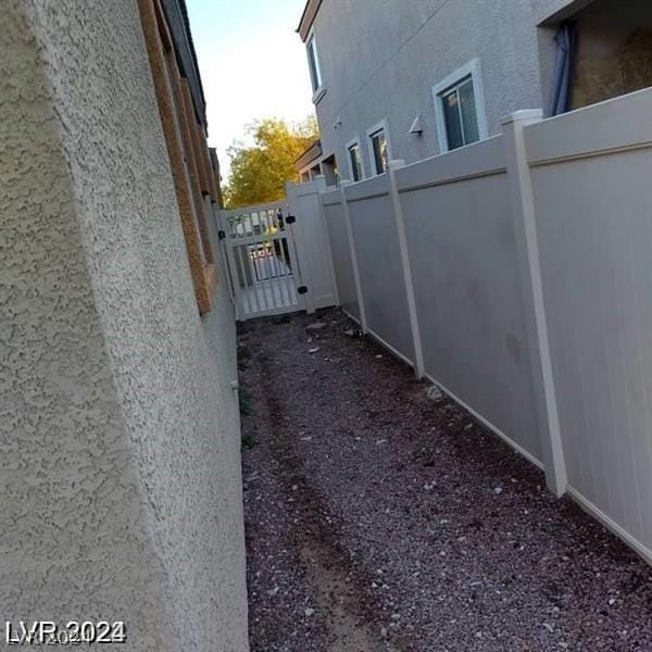 view of home's exterior with a gate, stucco siding, and fence