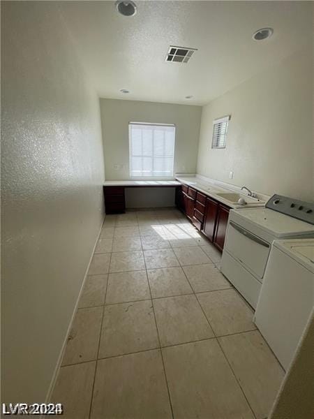 clothes washing area featuring visible vents, baseboards, light tile patterned floors, independent washer and dryer, and a sink