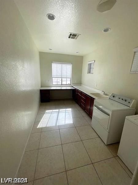 laundry area with washing machine and clothes dryer, visible vents, laundry area, light tile patterned flooring, and a sink