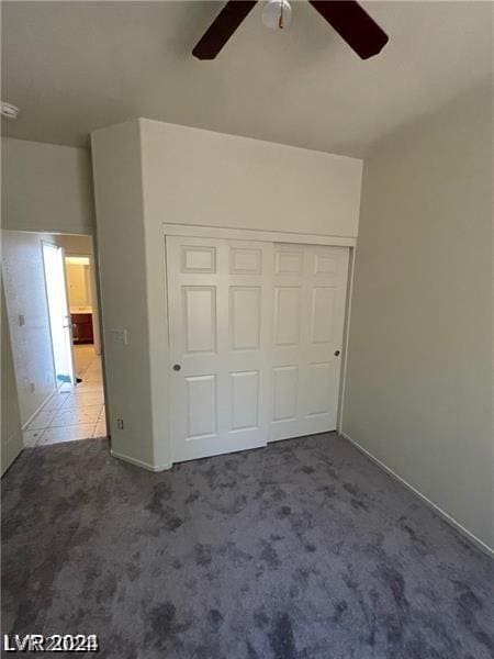 unfurnished bedroom with a closet, carpet flooring, and ceiling fan