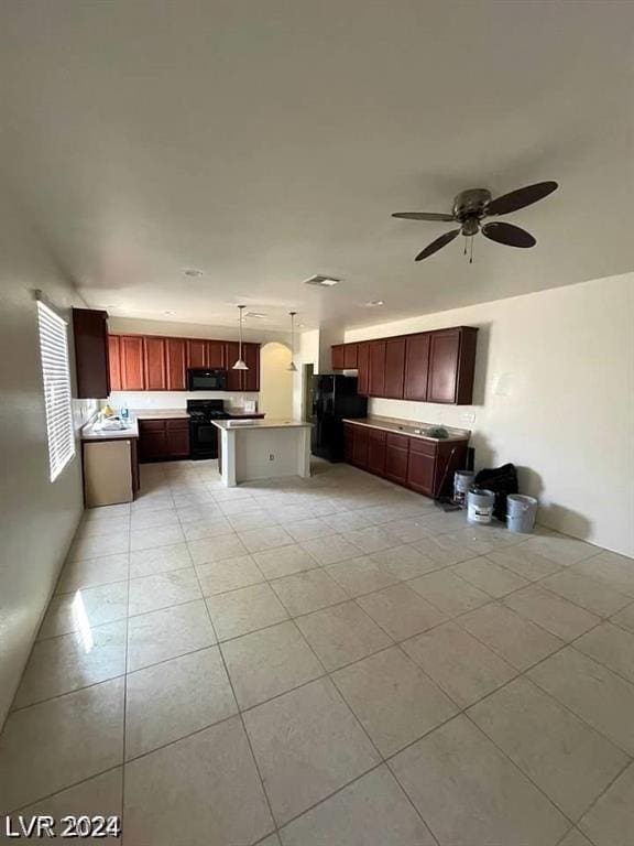 kitchen with black appliances, decorative light fixtures, open floor plan, and reddish brown cabinets