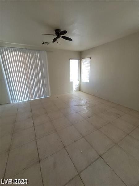 unfurnished room featuring visible vents and a ceiling fan