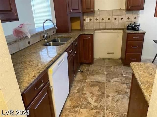 kitchen with tasteful backsplash, dishwasher, sink, dishwashing machine, and light stone counters