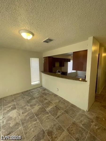 kitchen with kitchen peninsula and a textured ceiling