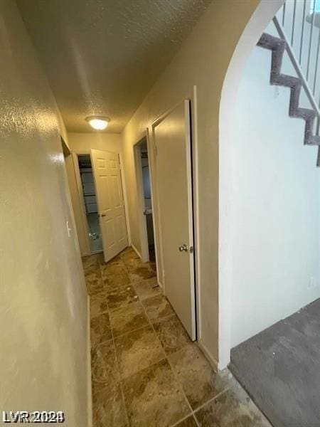 hall featuring a textured ceiling