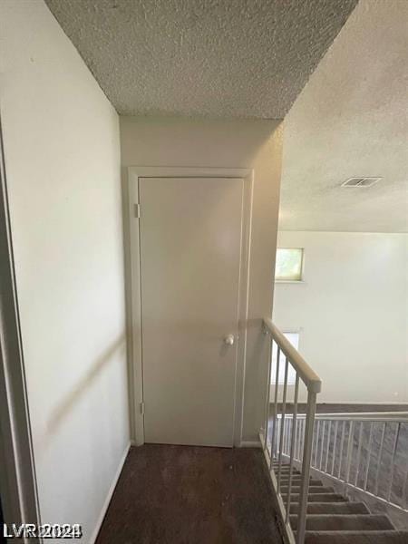 hallway featuring a textured ceiling and carpet