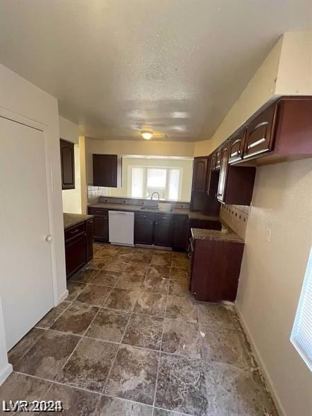 kitchen featuring tasteful backsplash, sink, dark brown cabinetry, white dishwasher, and a textured ceiling