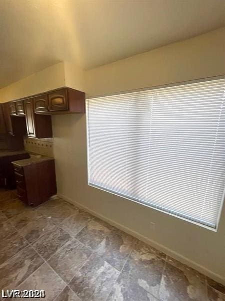 kitchen with lofted ceiling and dark brown cabinets