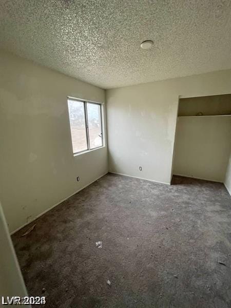 unfurnished bedroom with carpet floors and a textured ceiling