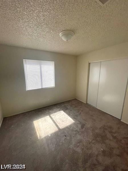 unfurnished bedroom with a closet, carpet, and a textured ceiling