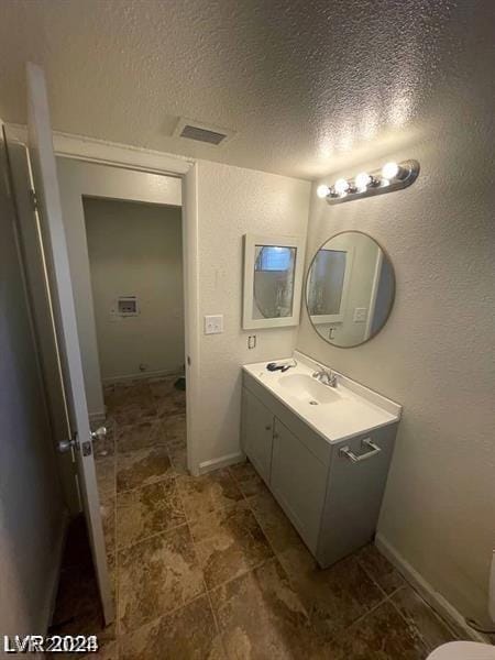 bathroom featuring vanity and a textured ceiling