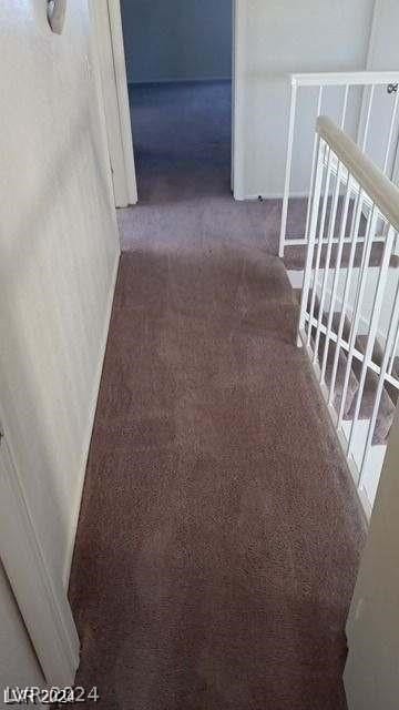 hall featuring dark carpet