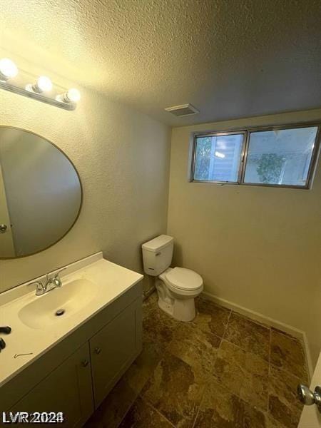 bathroom with vanity, a textured ceiling, and toilet