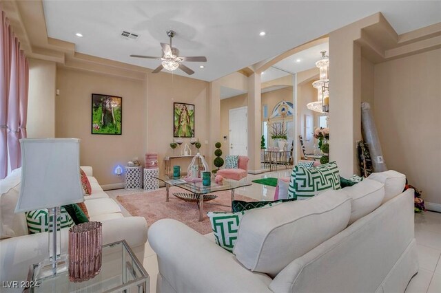 living room featuring ceiling fan with notable chandelier