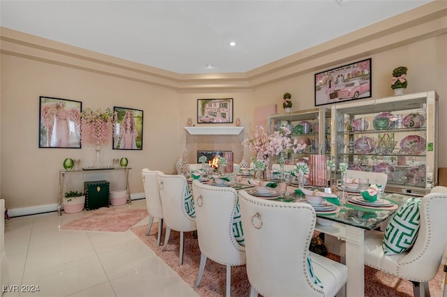 dining room with a tiled fireplace and light tile patterned floors