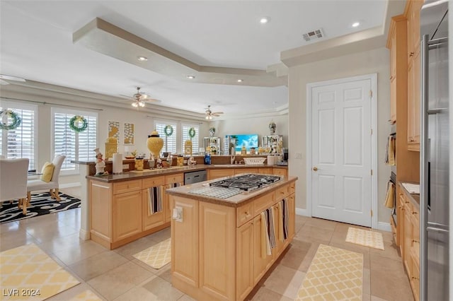 kitchen with stainless steel appliances, light brown cabinetry, kitchen peninsula, and a kitchen island