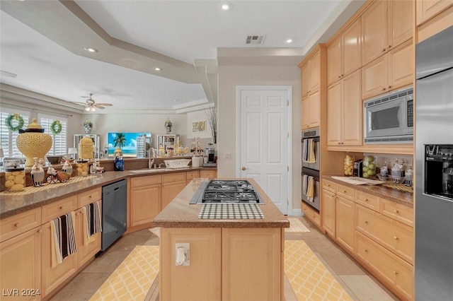 kitchen with light brown cabinetry, sink, a center island, kitchen peninsula, and stainless steel appliances