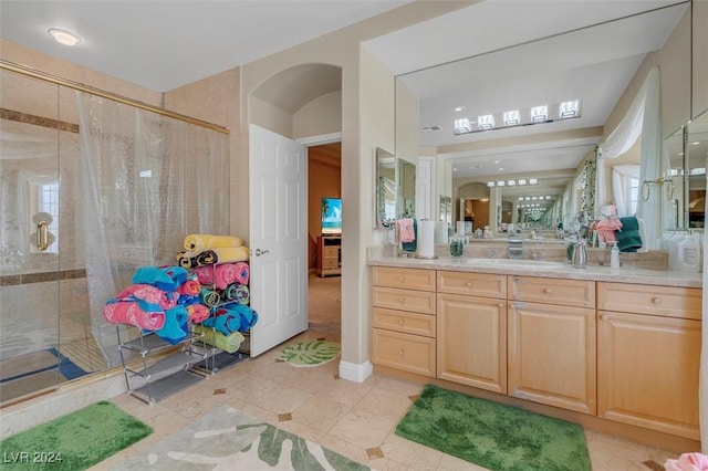 bathroom featuring tile patterned floors, vanity, and a shower with door