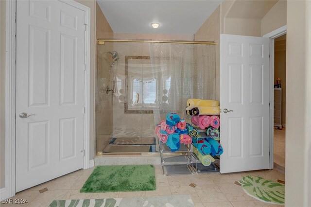 bathroom with an enclosed shower and tile patterned floors