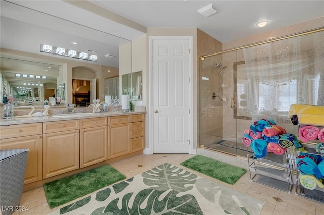 bathroom featuring vanity, tile patterned flooring, and a shower with shower door