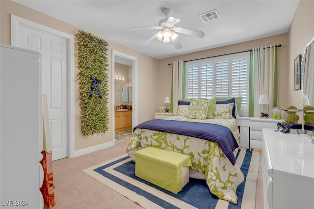 carpeted bedroom with ensuite bath and ceiling fan