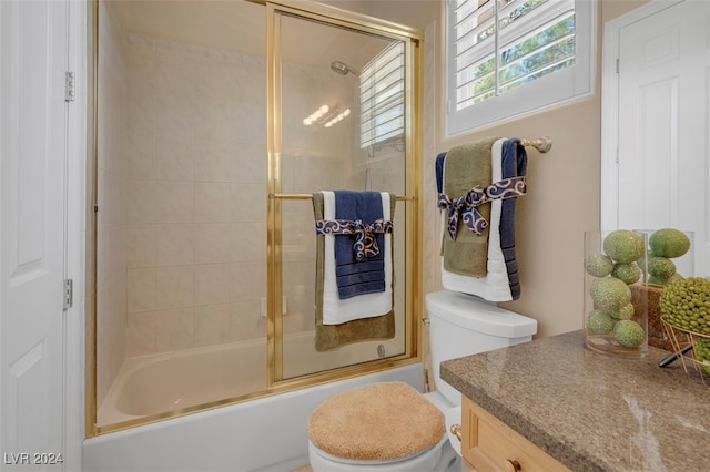 full bathroom with vanity, combined bath / shower with glass door, and toilet