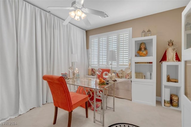 dining room with ceiling fan and light colored carpet