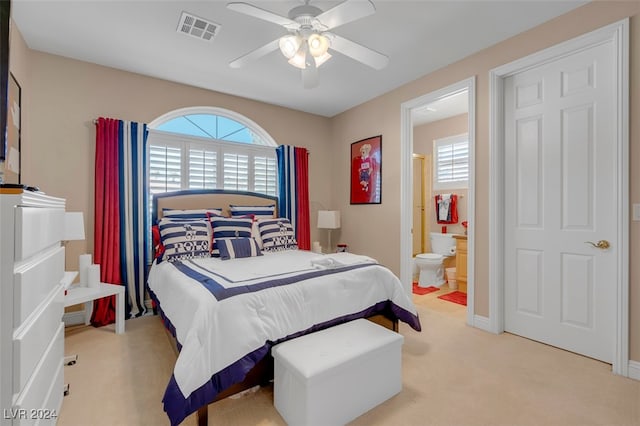 carpeted bedroom with ceiling fan and ensuite bath