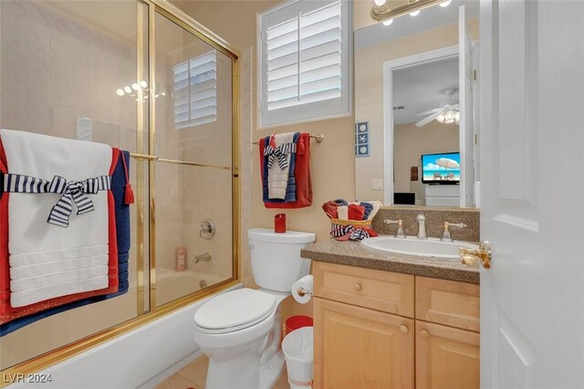 full bathroom featuring toilet, ceiling fan, vanity, and shower / bath combination with glass door