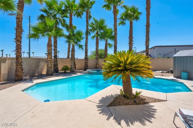 view of swimming pool with an in ground hot tub