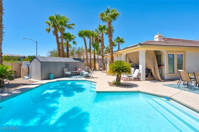 view of swimming pool featuring a storage shed and a patio