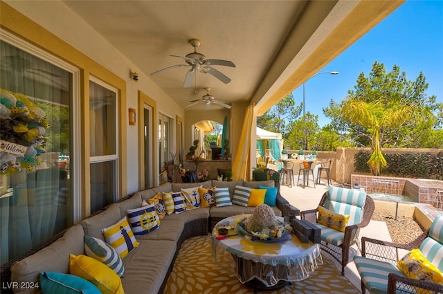 view of patio / terrace featuring outdoor lounge area, ceiling fan, and a bar