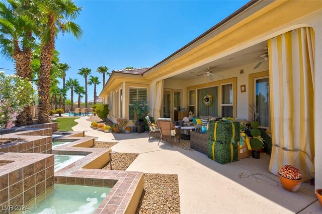 view of patio with a swimming pool with hot tub and ceiling fan