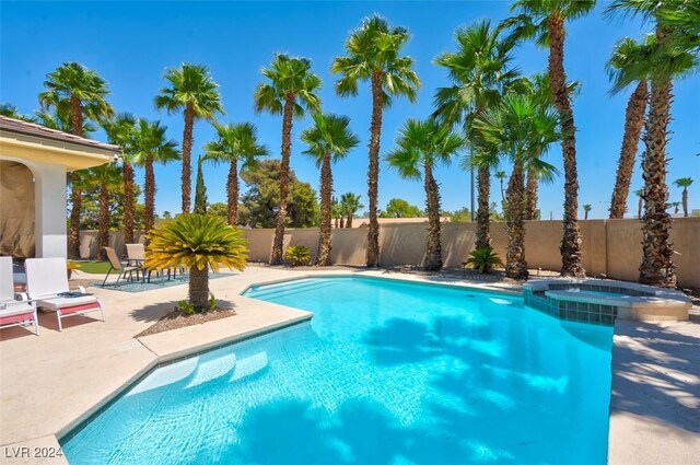 view of swimming pool featuring an in ground hot tub and a patio